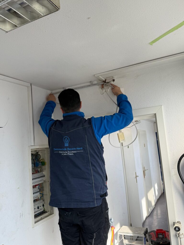 elektriker verlegt neue kabel bei einer altbausanierung