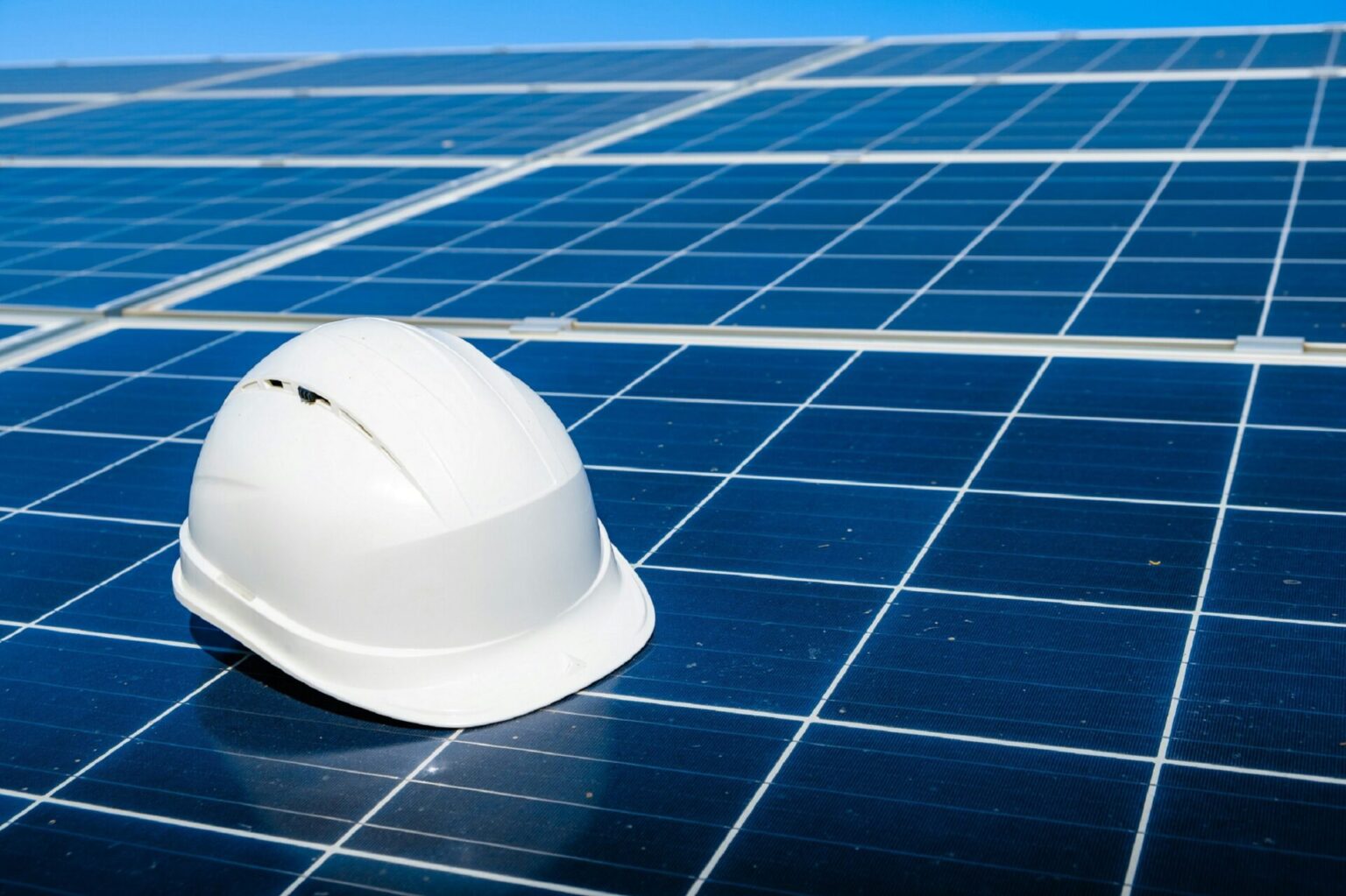 Weißer Schutzhelm auf Solarpanel-Anlage