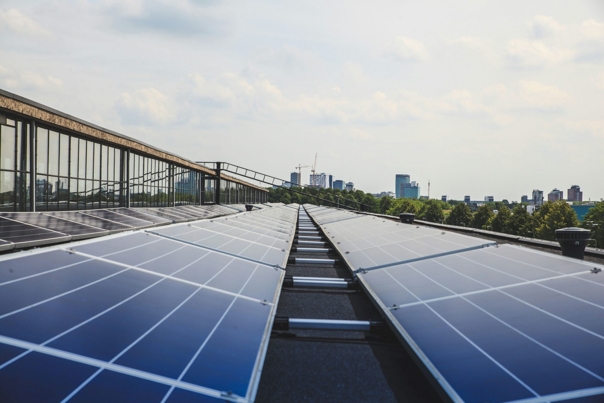 Solarmodule auf Industriedach mit Stadtsilhouette im Hintergrund