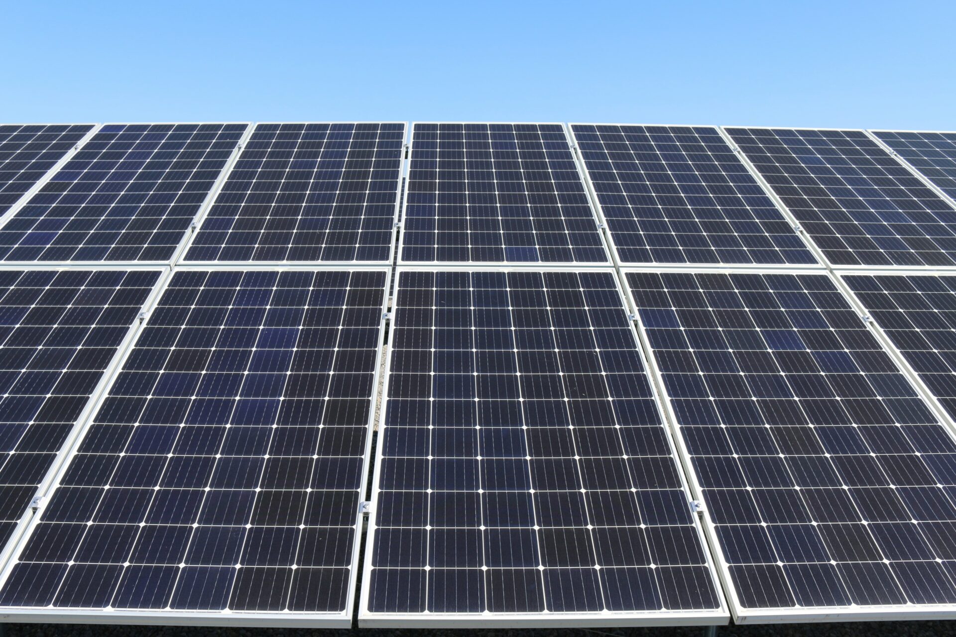 Reihen von Solarmodulen unter blauem Himmel