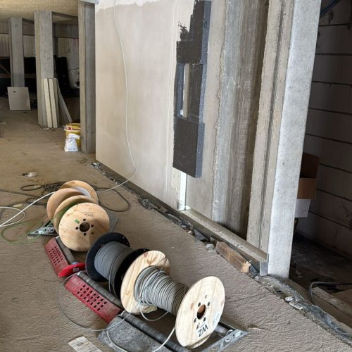 Baukabelspulen liegen auf Baustelle am Boden.